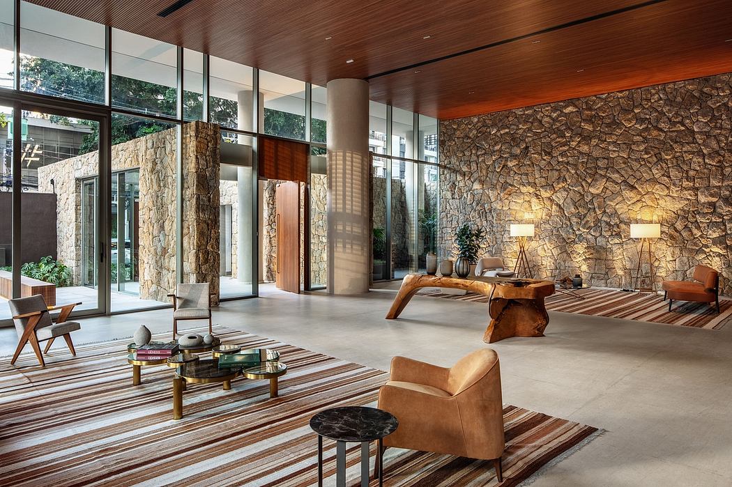 Spacious modern lobby with tall stone columns, wooden ceiling, and cozy seating areas.