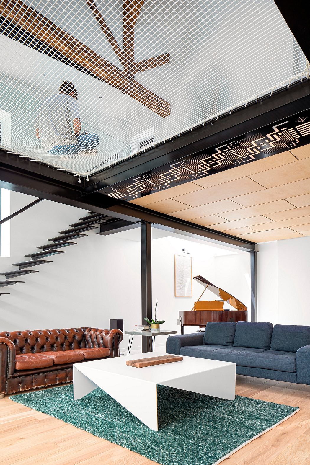 Sleek modern living room featuring a leather sofa, ornate ceiling, and geometric rug.