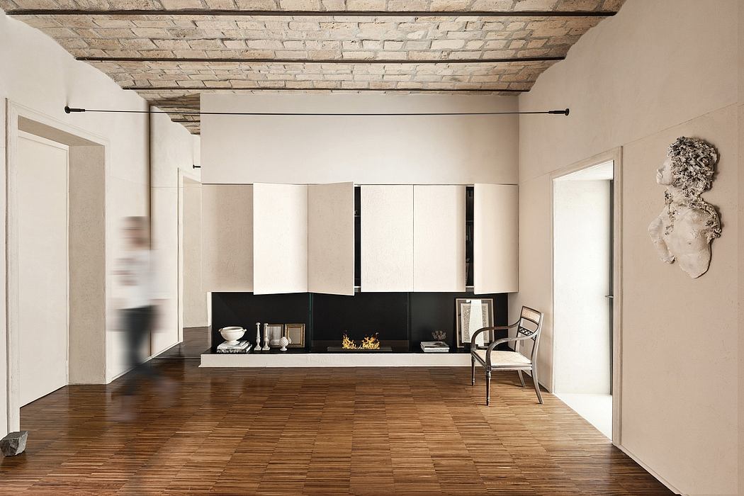 Minimalist open-plan room with exposed brick ceiling, built-in fireplace, and wood floors.