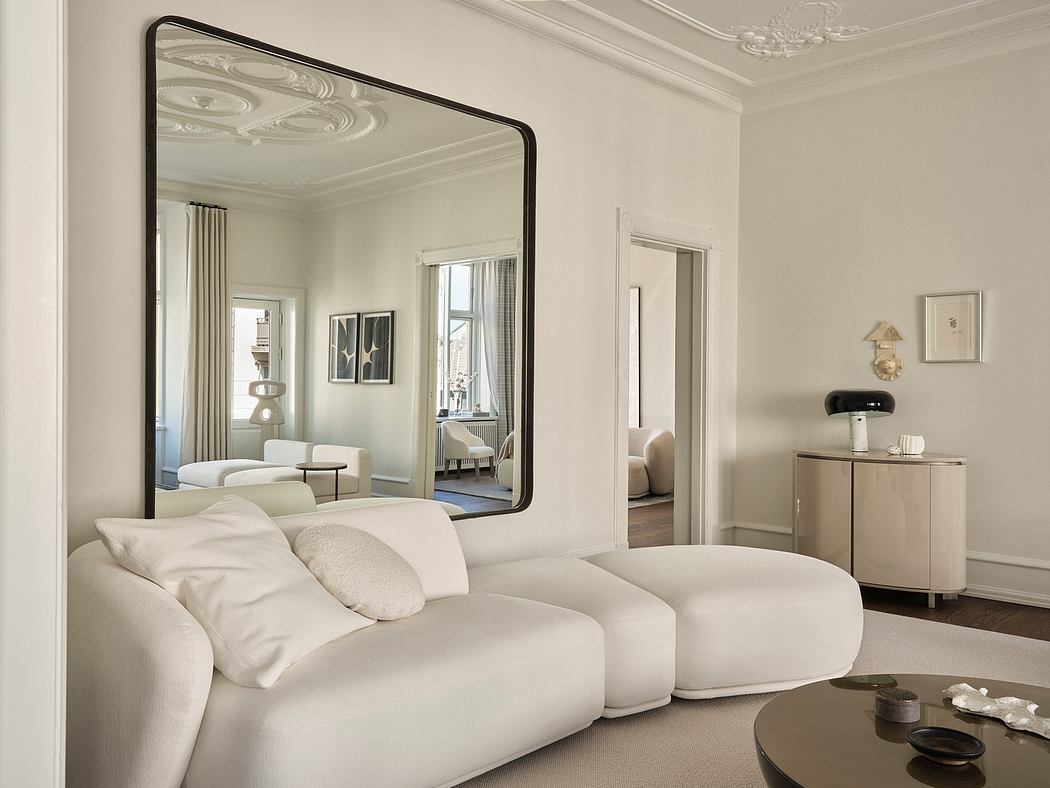 Elegant room with ornate ceiling, large mirror, and comfortable seating arrangement.