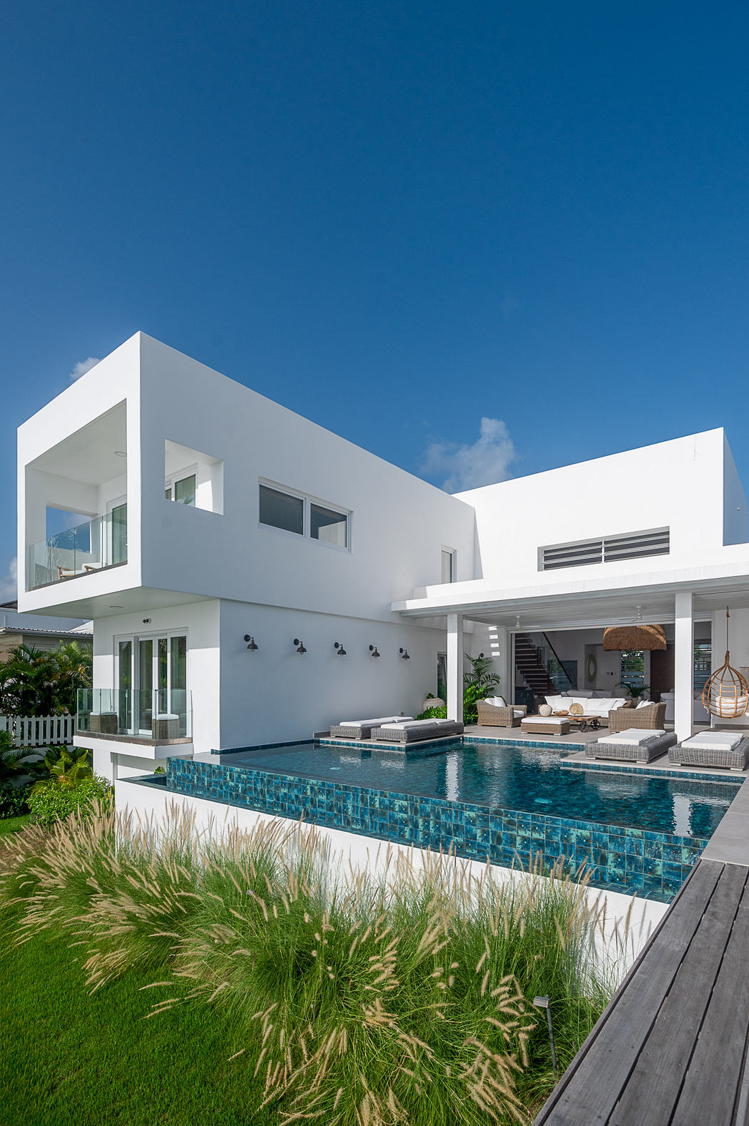 A modern, minimalist home with a sleek design, glass walls, and a beautiful pool.