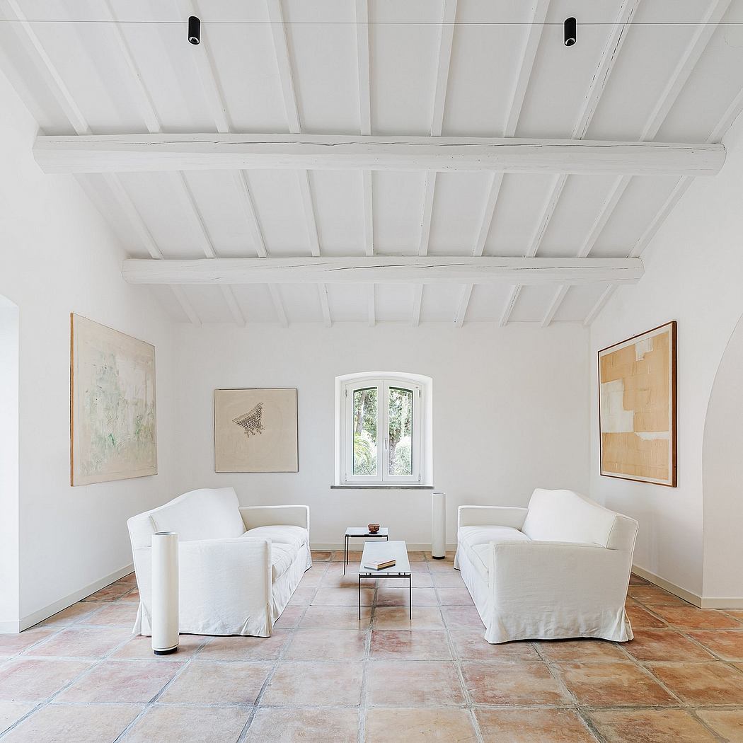 The room features a vaulted white ceiling, arched window, and tile flooring that creates a serene, minimalist ambiance.