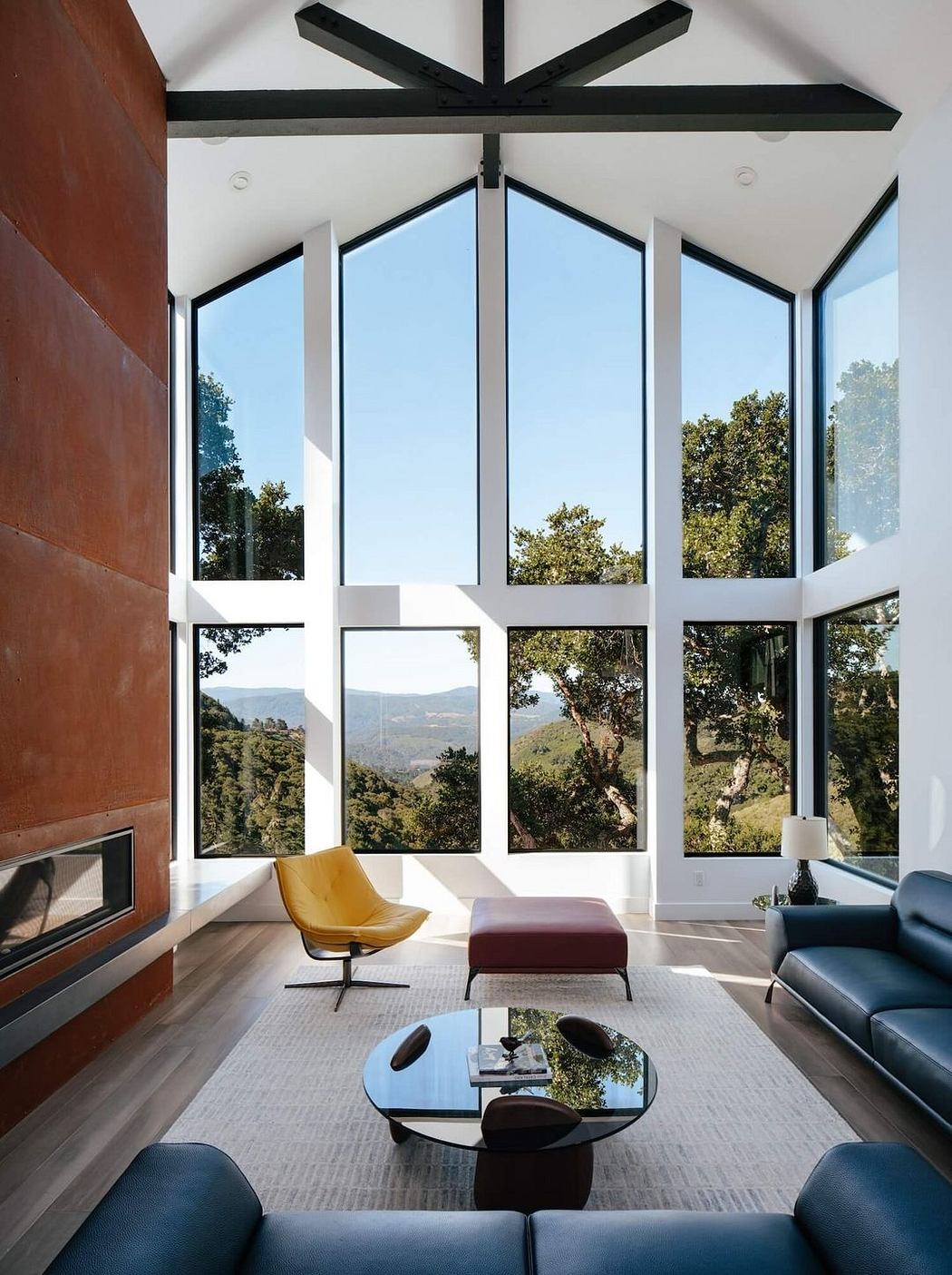 Expansive glass walls offer panoramic mountain views in this modern living space.