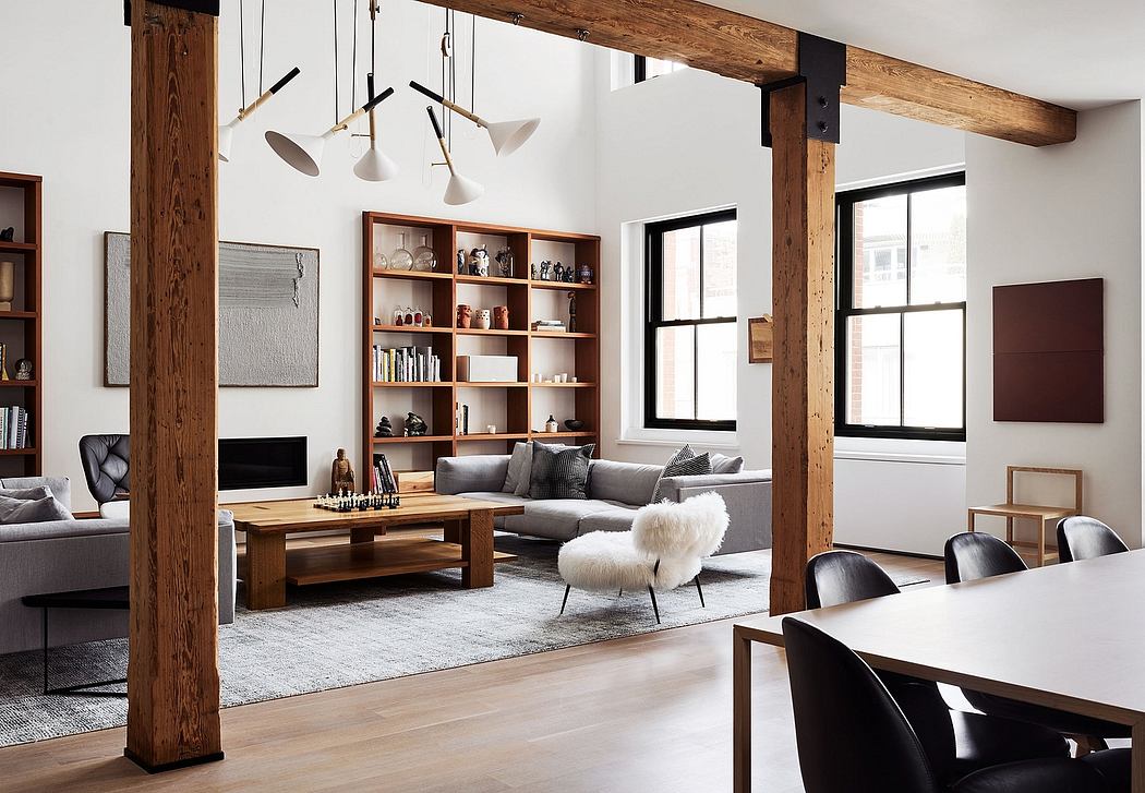 Cozy modern loft with exposed wooden beams, built-in shelves, and a plush sectional sofa.