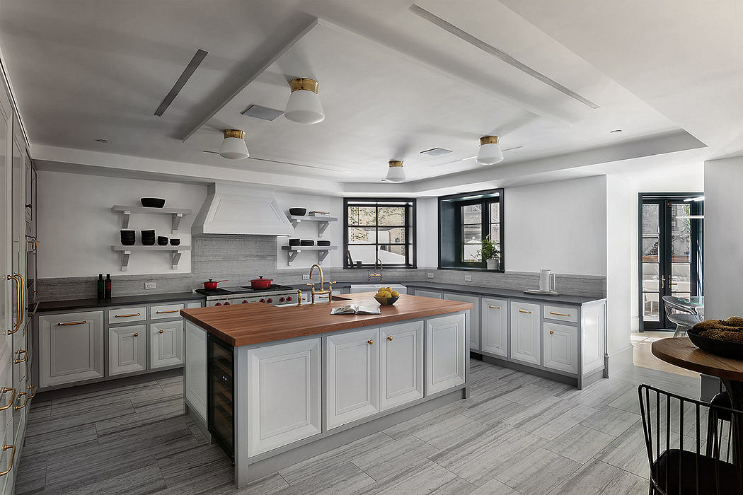 Spacious modern kitchen with gray cabinetry, wooden countertops, and recessed lighting.
