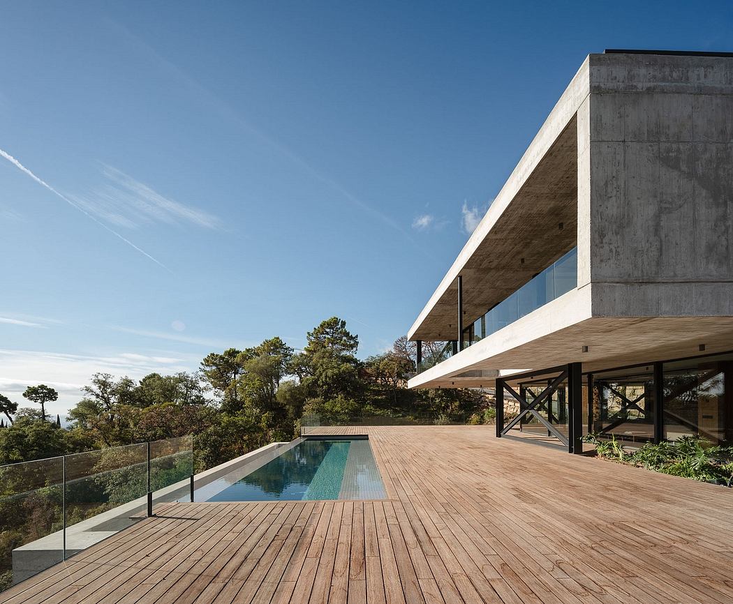 Sleek, modern architecture with expansive glass walls, wooden deck, and infinity pool.