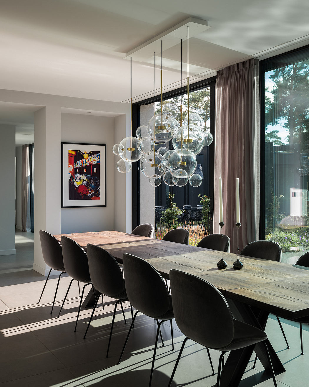 Sleek, modern dining room with a striking glass pendant light fixture and wooden table.