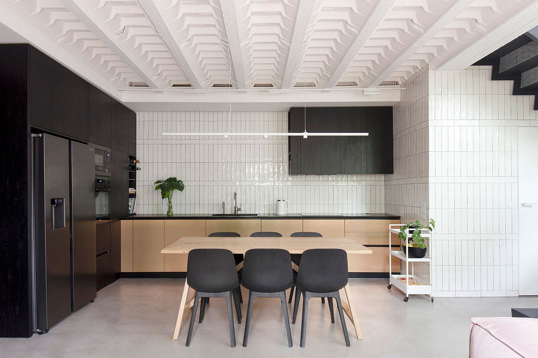 Modern kitchen with distinctive white ceiling beams, minimalist cabinetry, and sleek dining table.