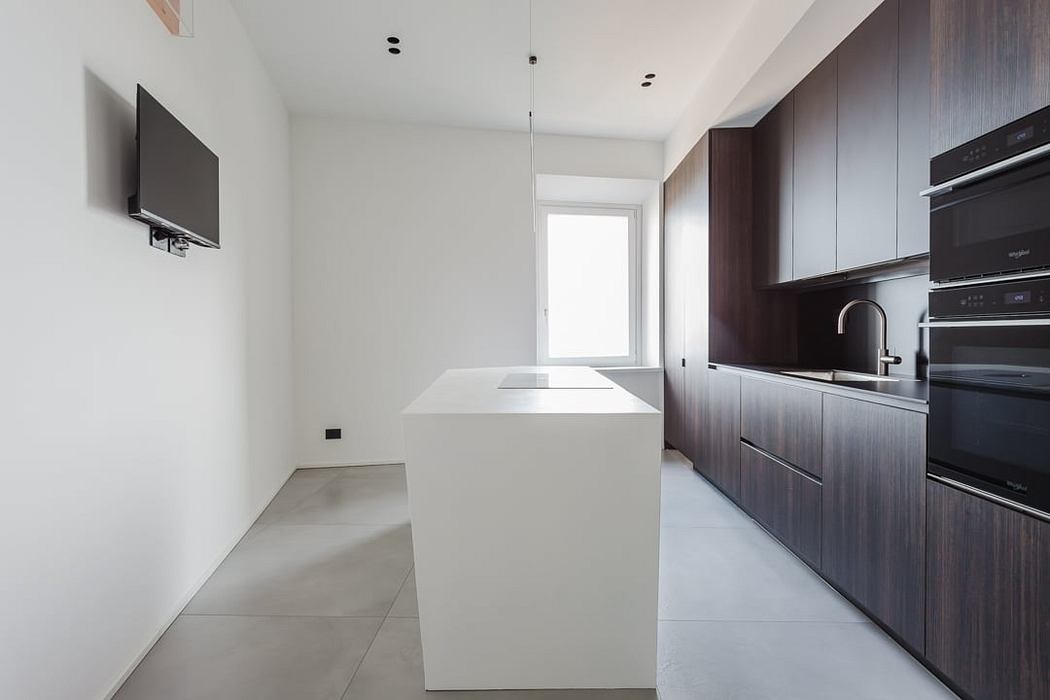 Modern kitchen with sleek dark wood cabinets, white countertops, and minimalist design.