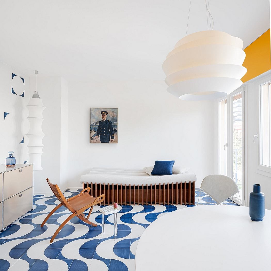 A bright, modern room with minimalist furniture, patterned floor, and a striking light fixture.