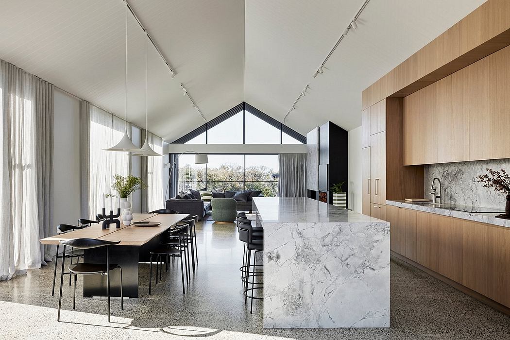 Bright, open-concept living space with marble kitchen island, track lighting, and wood accents.
