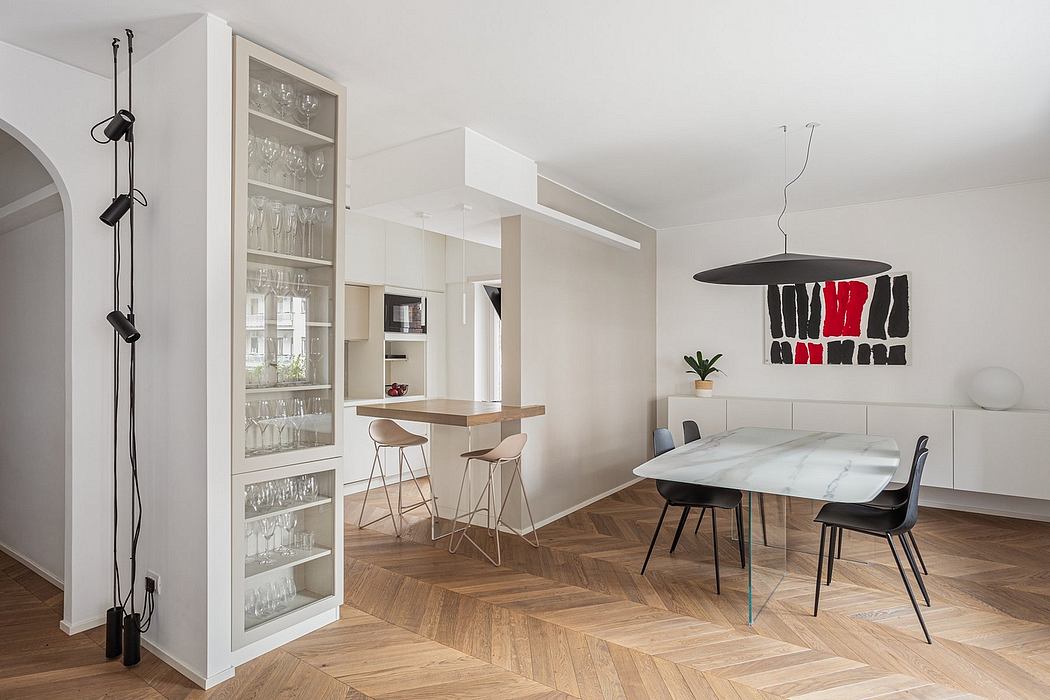 Sleek, modern kitchen and dining area featuring minimalist furnishings and a bold abstract artwork.