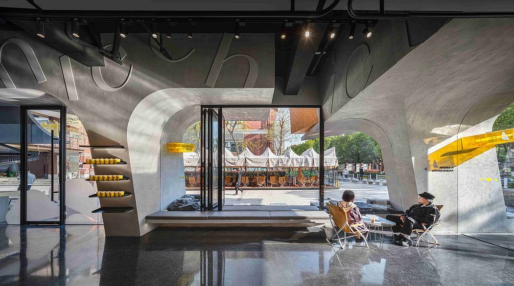 Spacious modern interior with curved walls, reflective floors, and seating area overlooking outdoor scene.