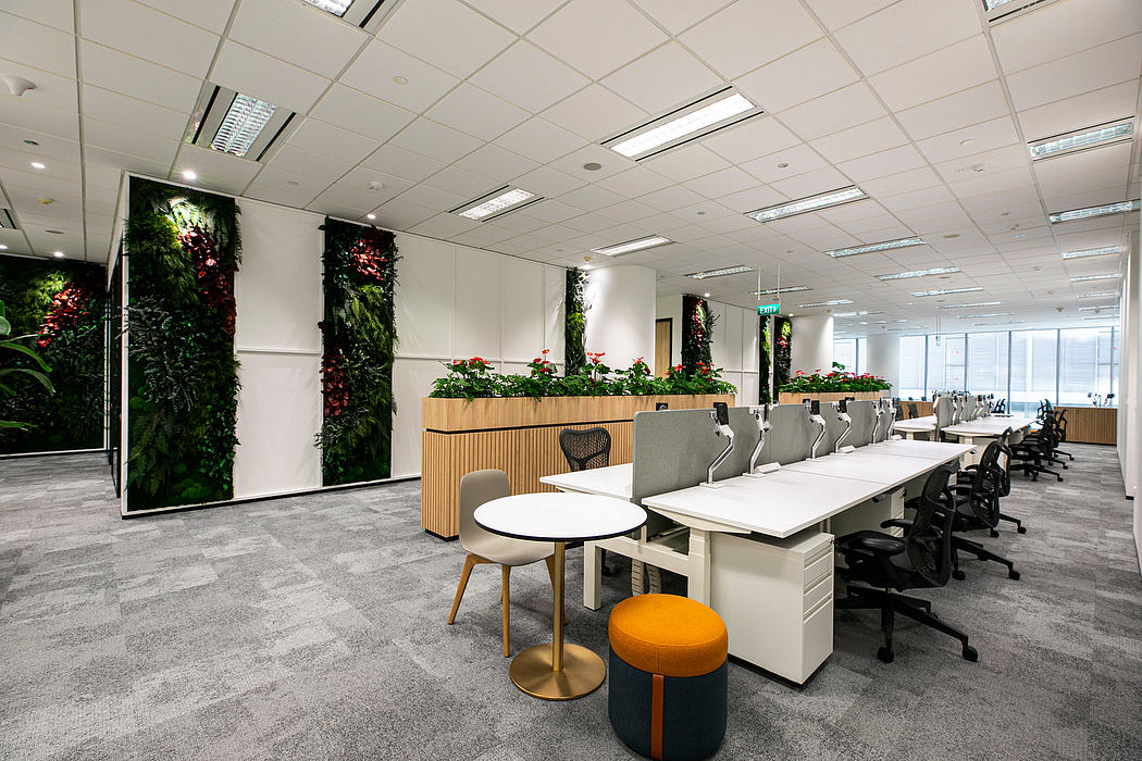 A modern office space with lush greenery, sleek furniture, and natural lighting.