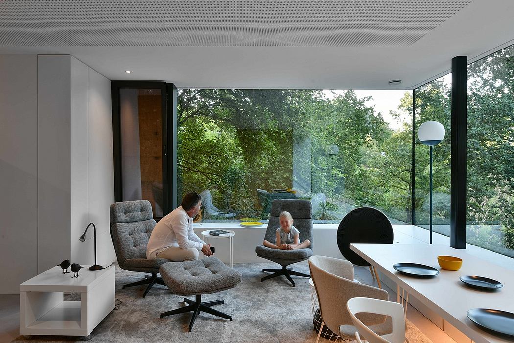 A sleek, modern living space with large windows offering a serene forest view.