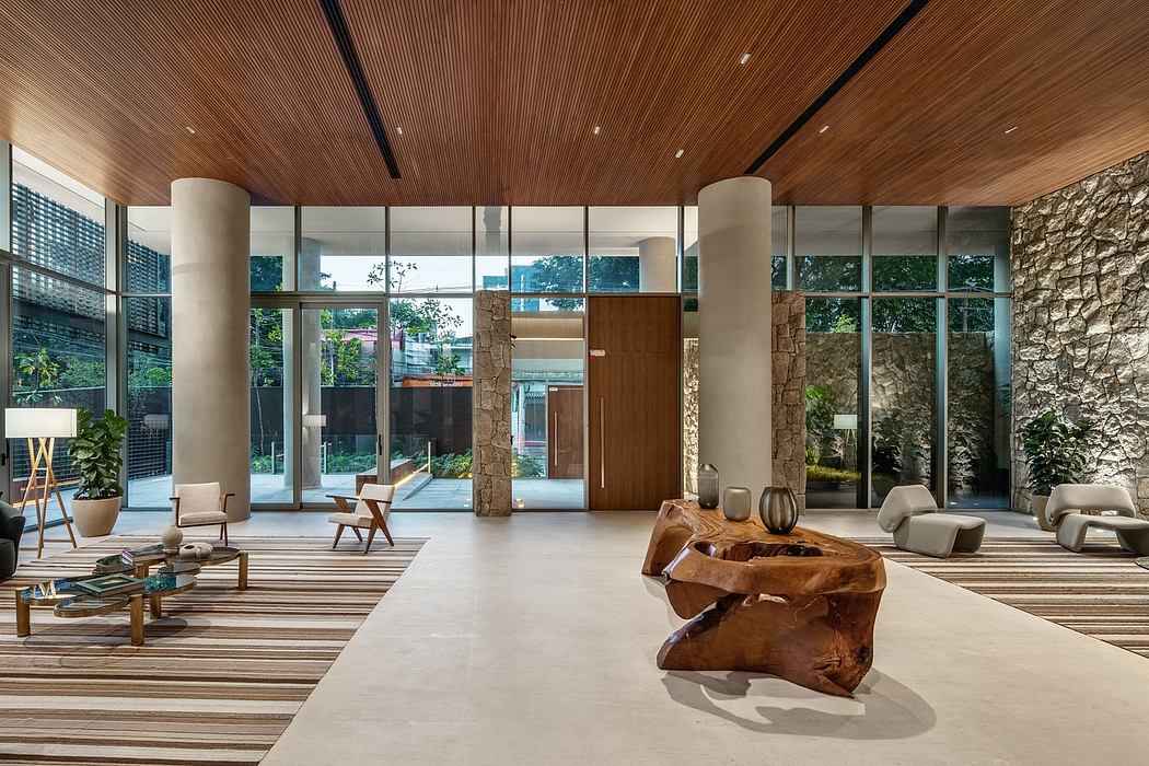 Spacious modern lobby with wooden ceiling, stone columns, and minimalist furniture.