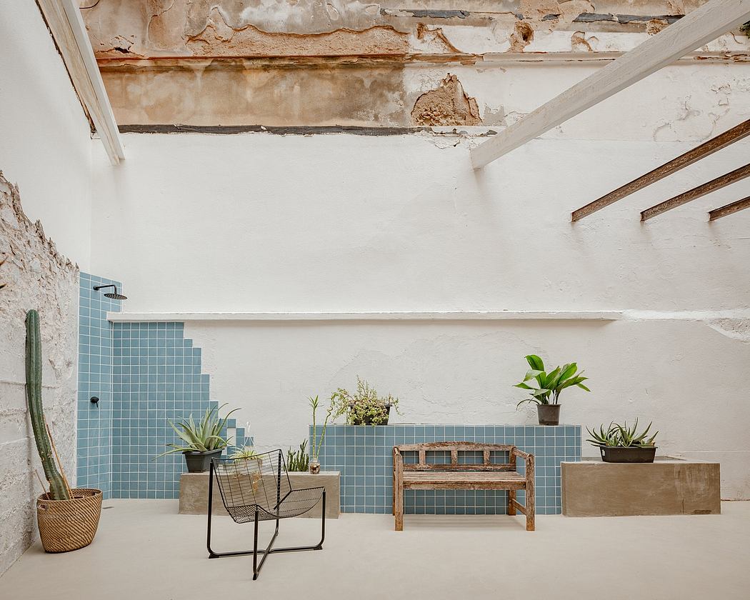 Rustic bathroom design with blue tile, potted plants, and wooden bench against textured walls.