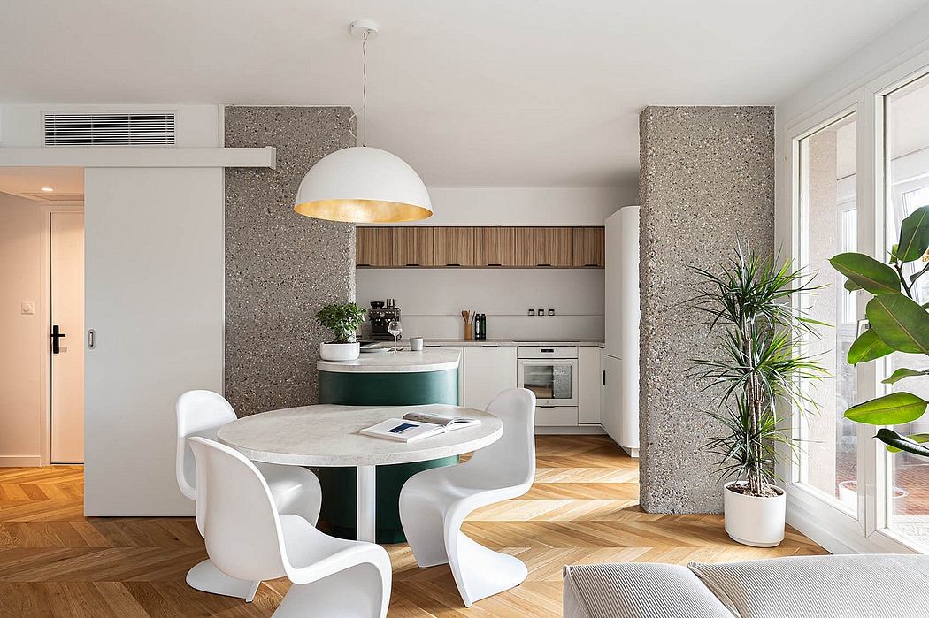 Sleek, modern kitchen with white furniture and textured stone walls; herringbone wood floor.