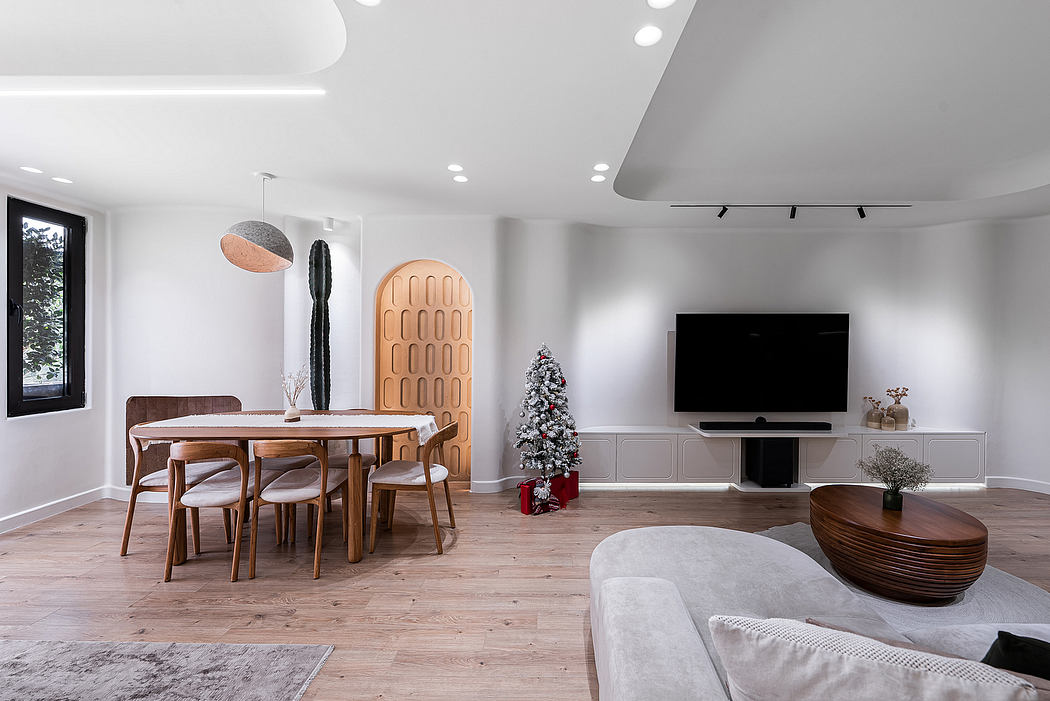 Modern open-concept living space with wooden furniture, textured walls, and a Christmas tree.