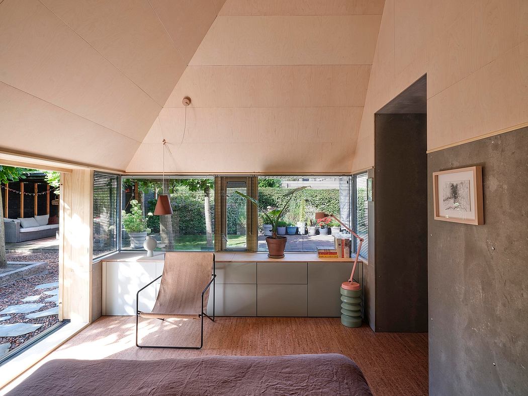 Modern, open-plan bedroom with floor-to-ceiling windows, wooden floors, and stylish furnishings.