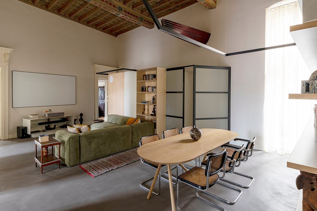 Warm, open-concept living space with wooden ceiling beams, built-in shelving, and modern furnishings.