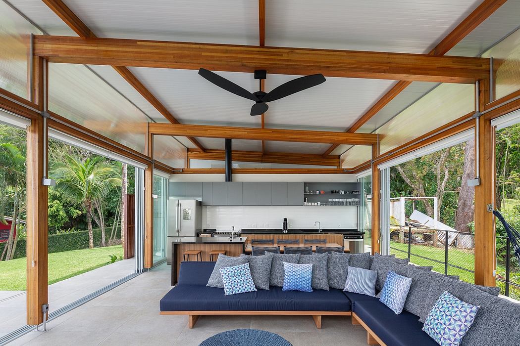 Spacious, open-concept living space with wooden beams, floor-to-ceiling windows, and modern furnishings.