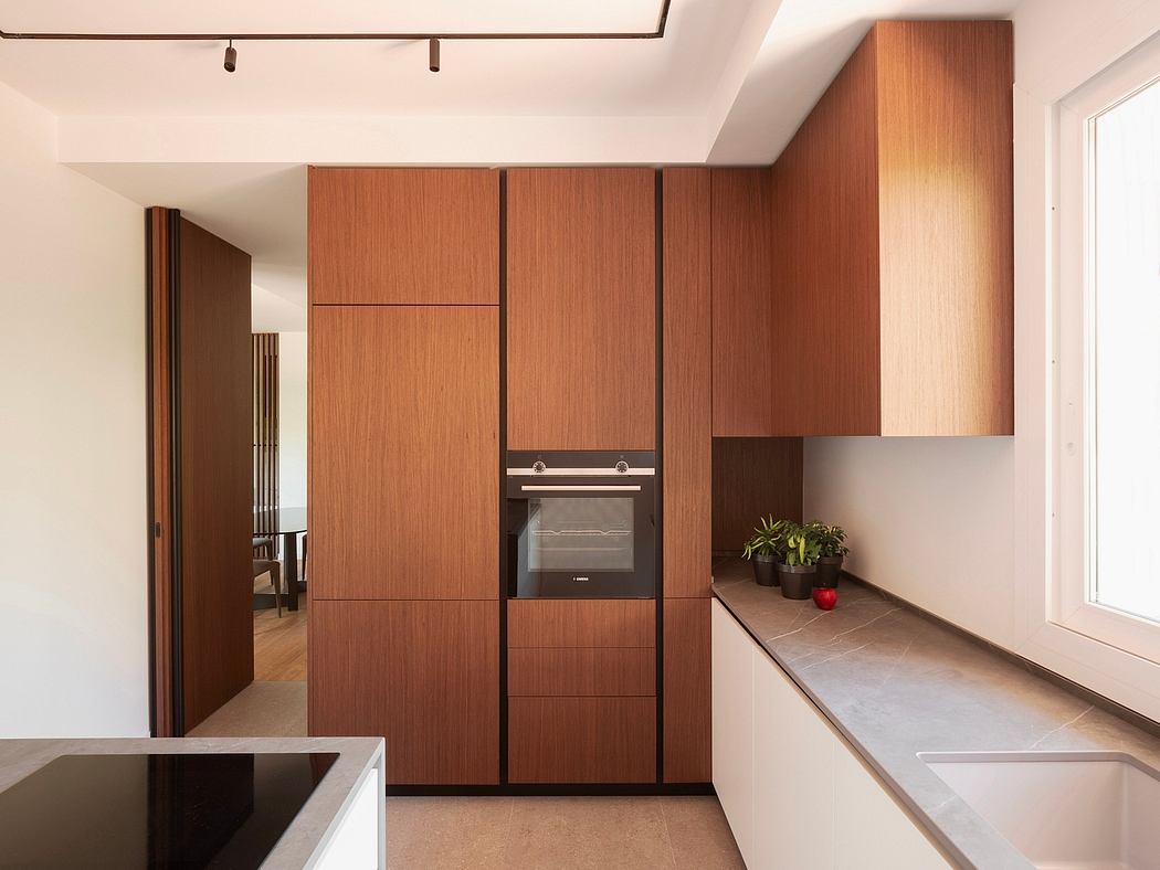 Warm-toned wooden kitchen cabinets and countertops with modern appliances and potted plants.