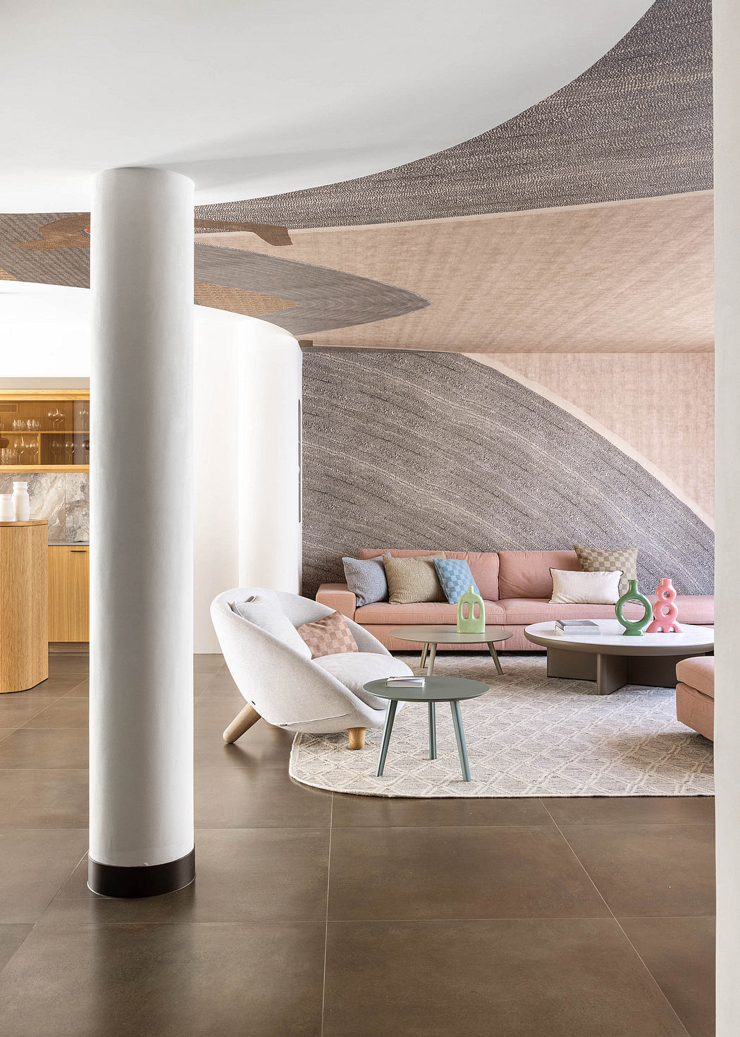 Serene living room with curved walls, muted colors, and geometric furnishings.