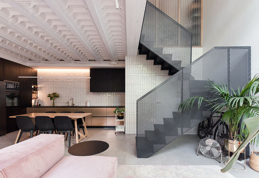 Sleek, modern interior with an ornate ceiling, staircase, and minimalist furnishings.