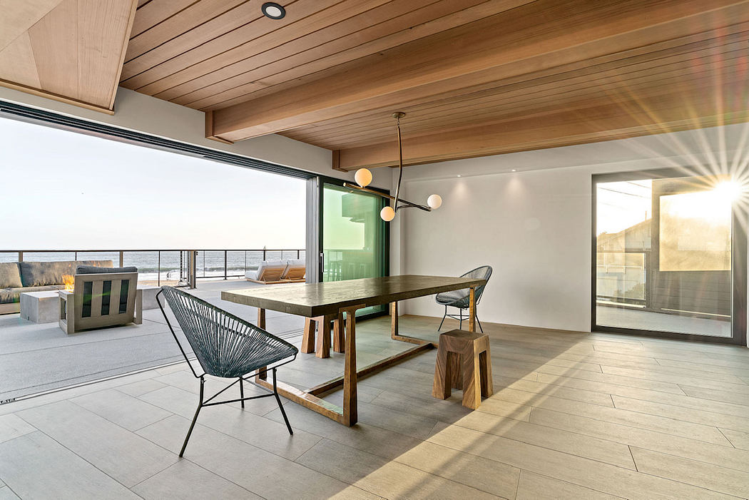 Spacious dining area with wooden beams, modern lighting, and panoramic ocean views.