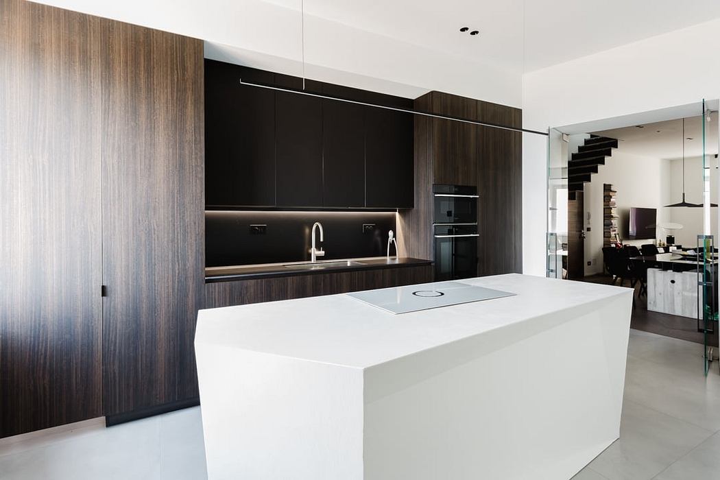 Sleek modern kitchen with dark wood cabinets, white countertops, and minimalist design.