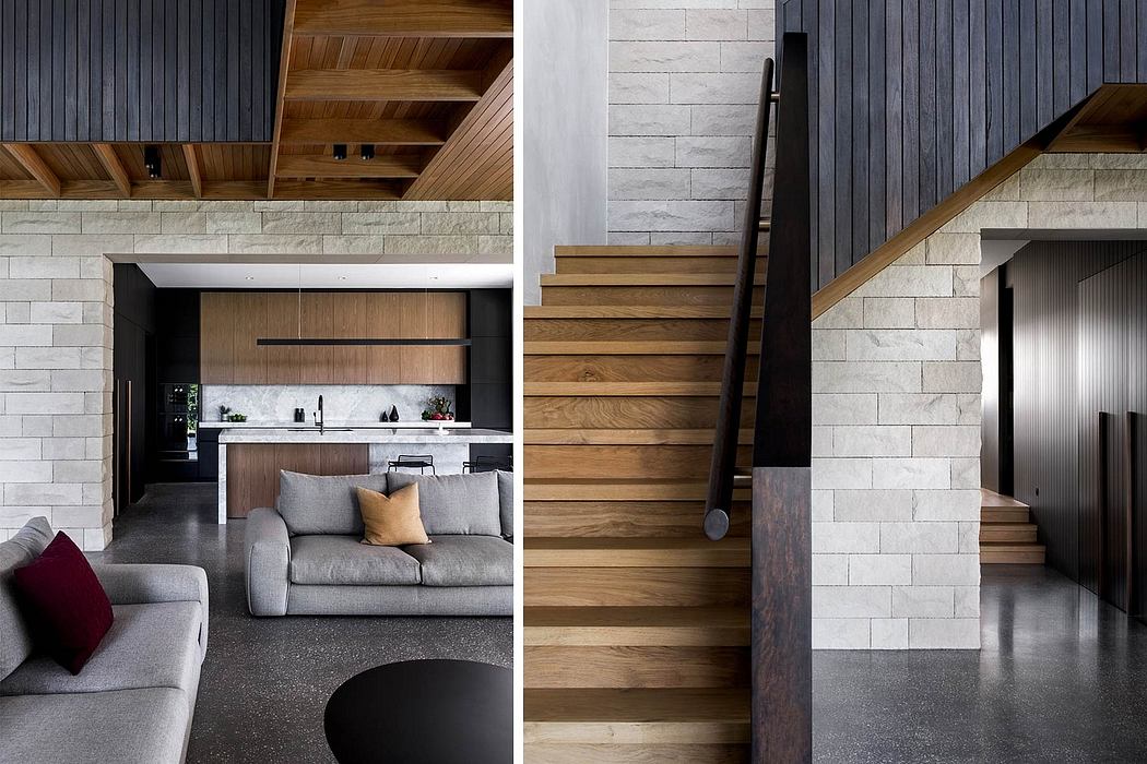 Cozy living room with sleek kitchen, wooden staircase, and textured stone walls.