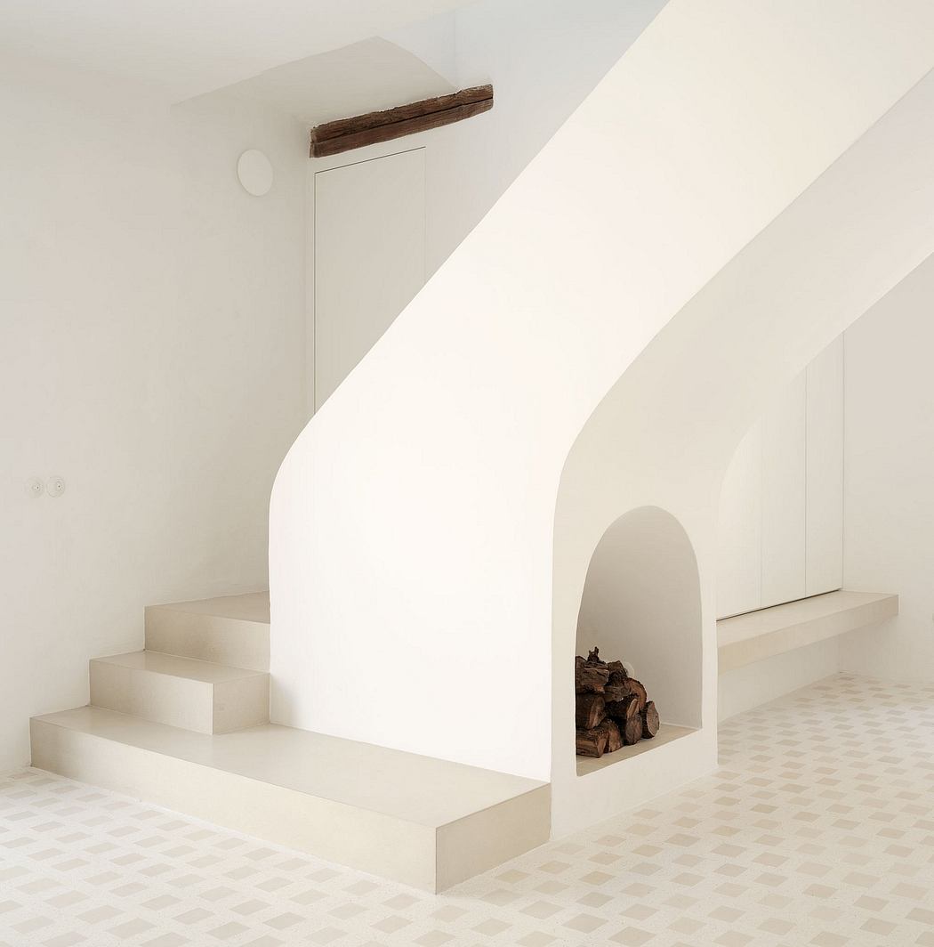 Modern, minimalist interior design with arched niche, steps, and tiled floor.