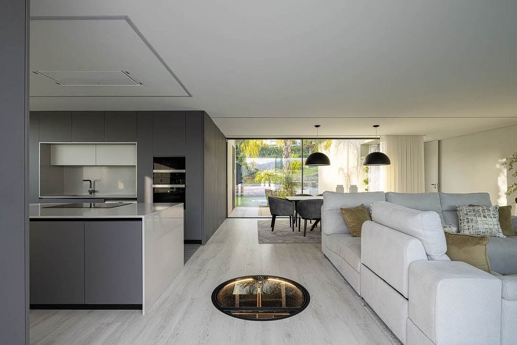 Contemporary, open-concept living area with sleek, modern kitchen and large windows.