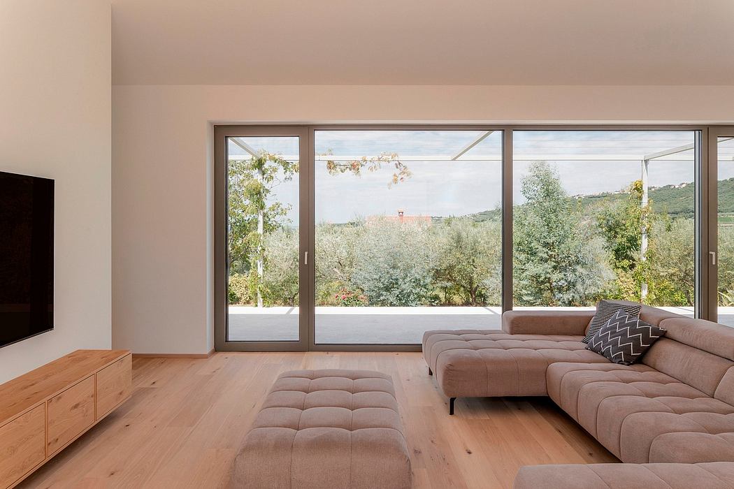 Spacious living room with large windows offering panoramic views of lush greenery.