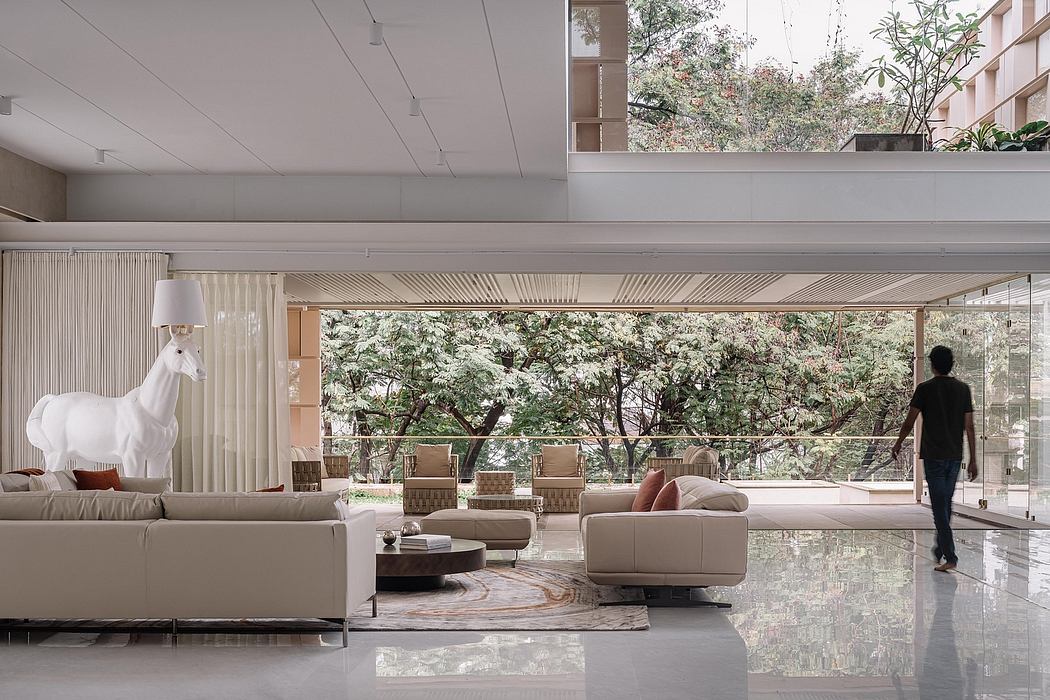Sleek, modern living room with floor-to-ceiling windows overlooking lush greenery.