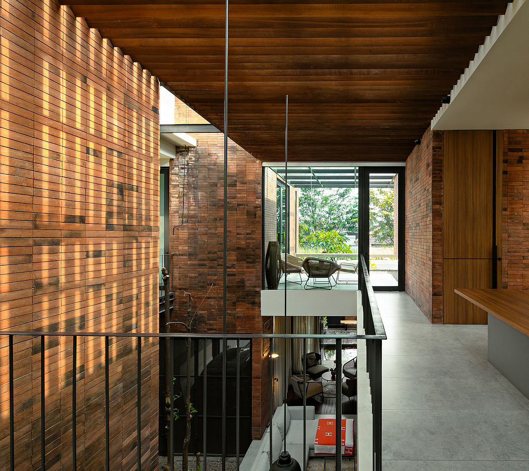 An interior with wooden ceilings, brick walls, and large windows overlooking greenery.