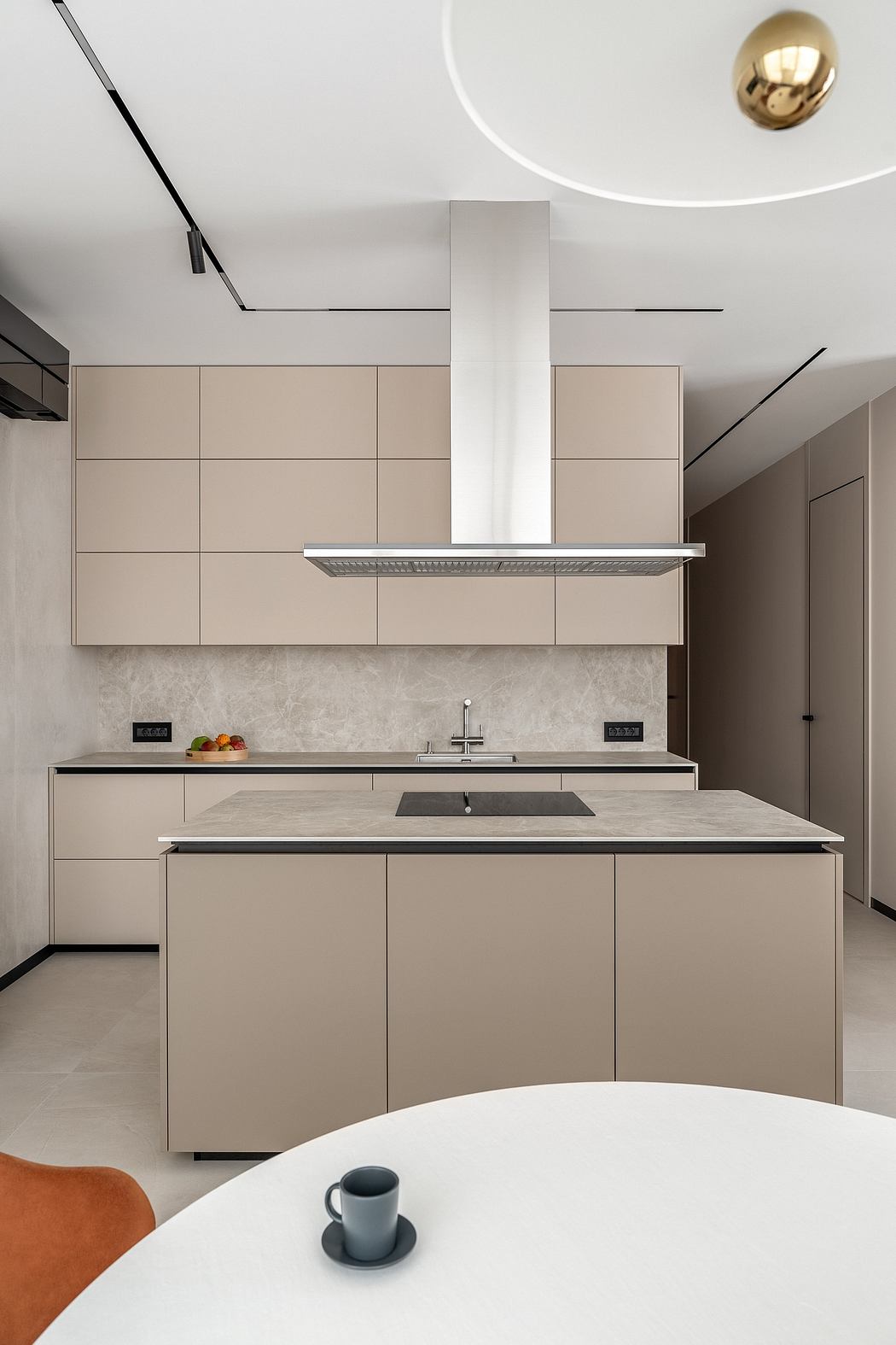 A modern, minimalist kitchen with sleek cabinetry, a pendant light, and a marble countertop.