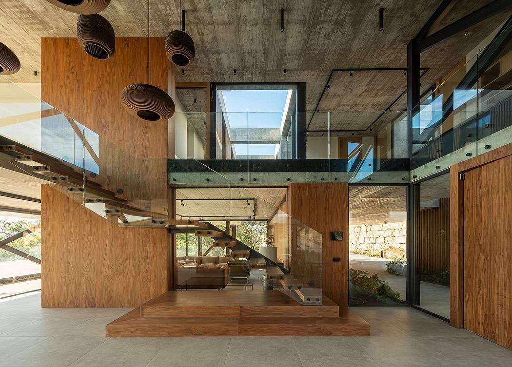 A modern, wood-paneled interior with a spacious layout, glass walls, and sculptural lighting fixtures.