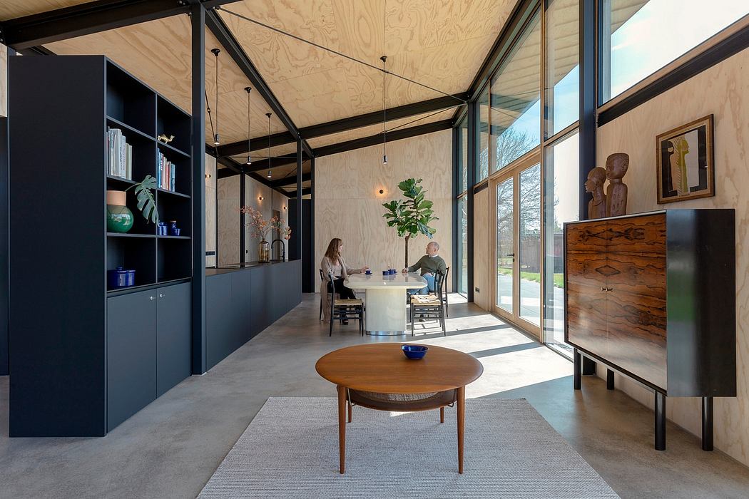 Bright, airy interior with exposed wooden beams, large windows, and modern furniture.