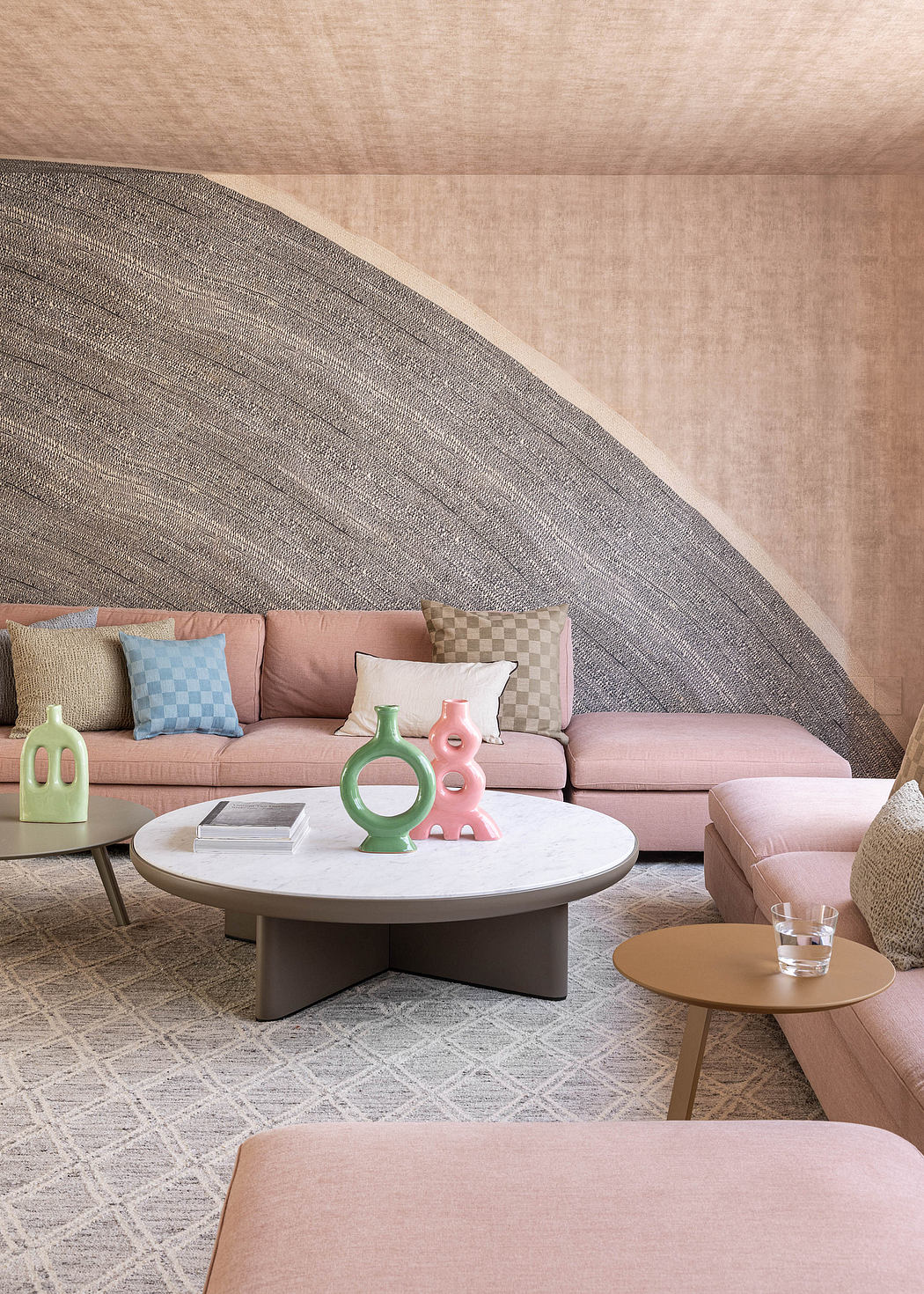 Warm, modern living space with plush seating, decorative vases, and a round coffee table.