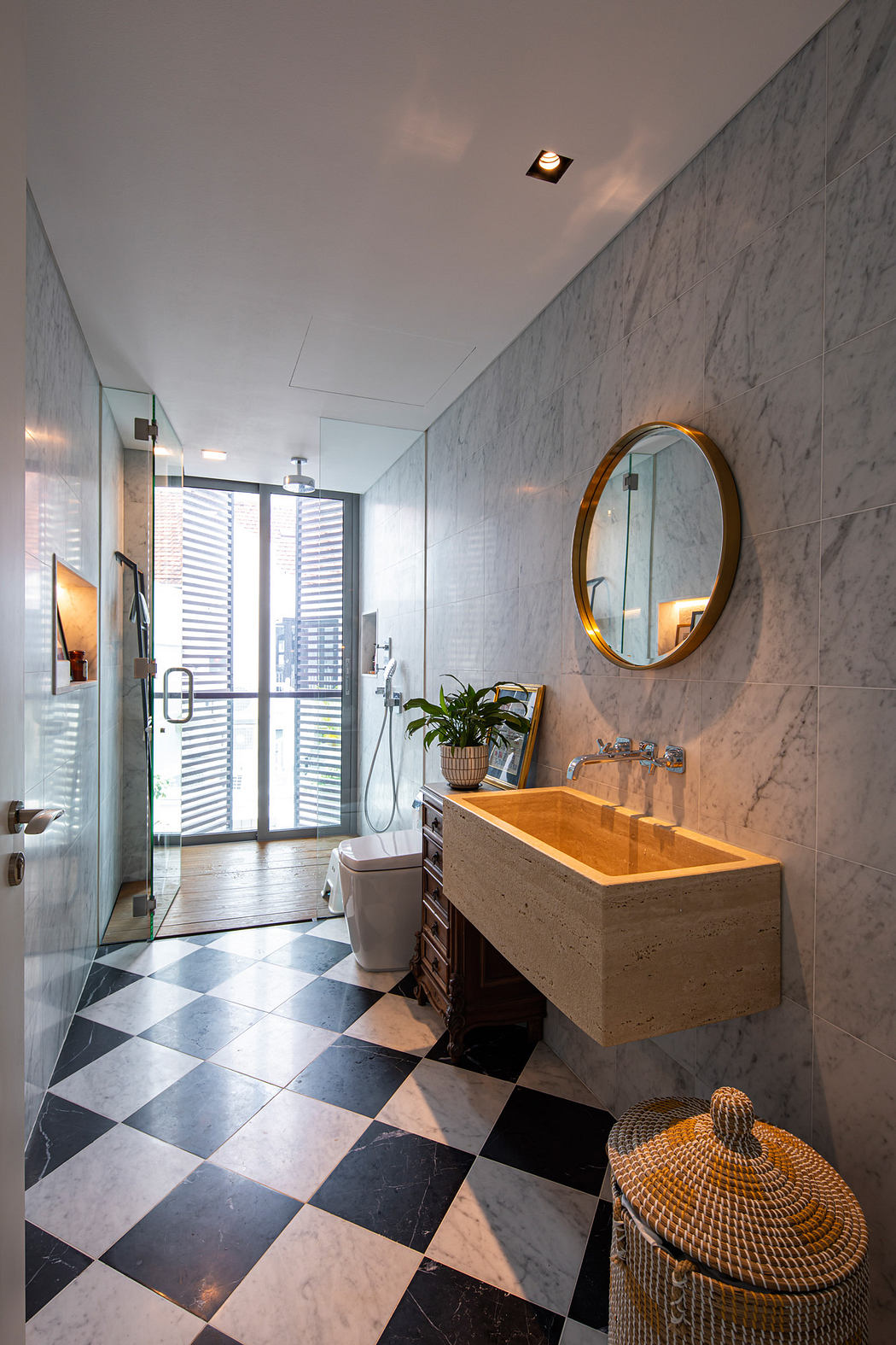 Spacious modern bathroom with marble walls, checkered floor, and a stylish vanity.