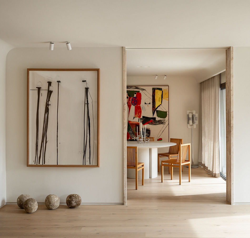 Minimalist interior with framed artwork, wooden furniture, and natural stone accents.