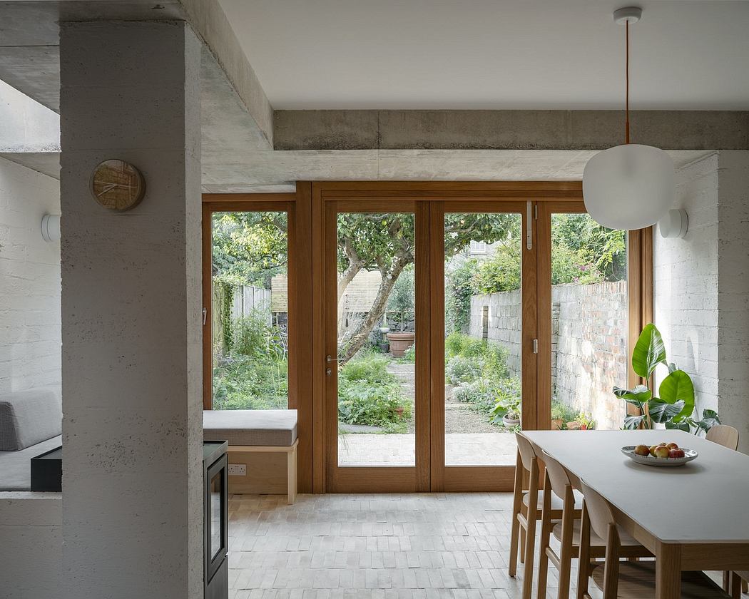 Bright, modern kitchen with large wood-framed windows overlooking a lush garden.