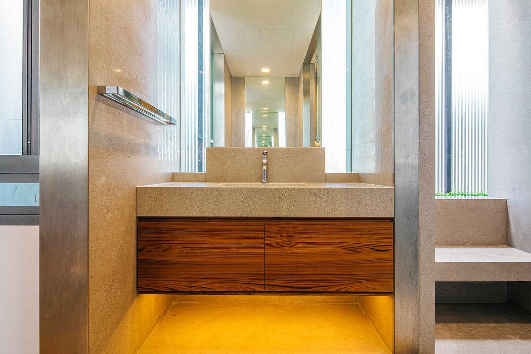 Minimalist bathroom design with a large vanity, wooden drawers, and stone countertop.
