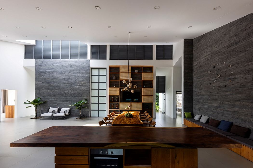 Expansive modern interior with stone accent wall, built-in shelving, and wooden dining table.