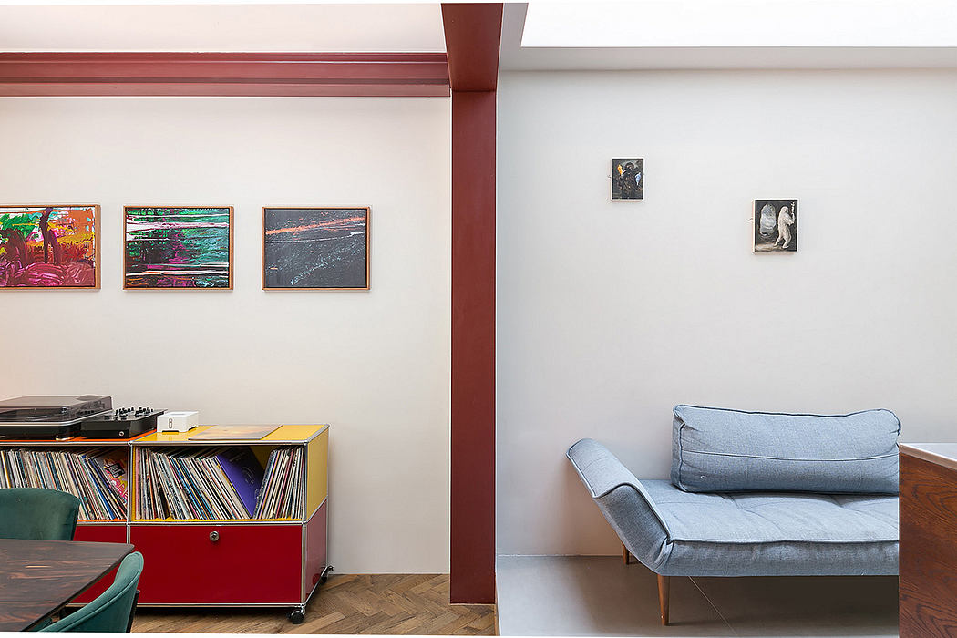 Minimalist living room with record storage, artwork, and a comfortable gray sofa.