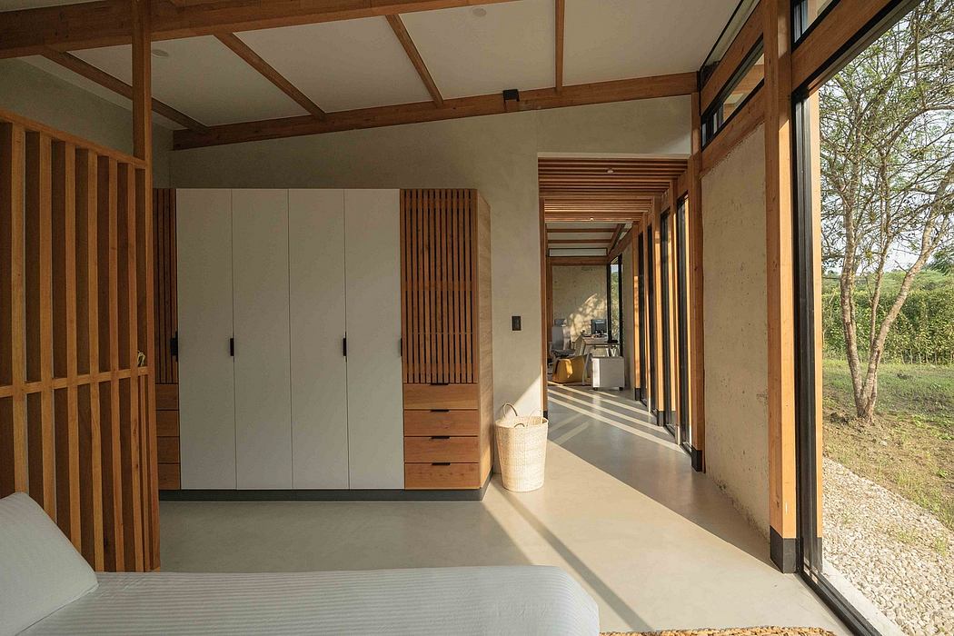 A modern, wooden-framed interior with minimalist furnishings and expansive windows overlooking nature.