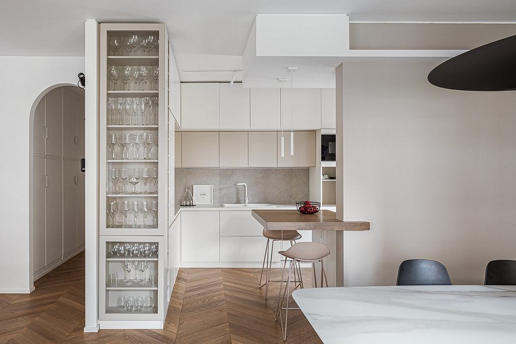 Minimalist kitchen with white cabinets, glass display, and wooden dining table.