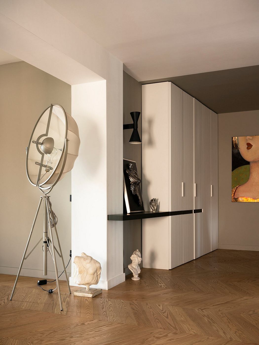 A modern living room with a large wall unit, pendant lighting, and sculptural decor.